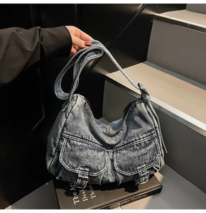 Detail of vintage denim hobo bag featuring two front cargo pockets and metal buckles