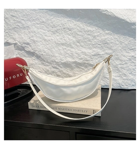 Detail of white crescent bag with glossy leather texture and gold double zipper hardware