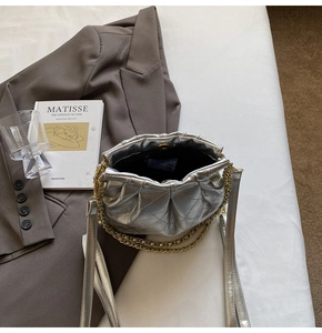 Top view of metallic silver quilted cloud bag showing interior and gold chain strap