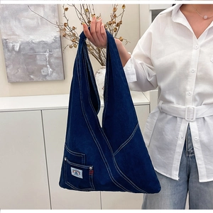 Close-up of dark blue denim tote bag texture with rainbow patch and outer pocket