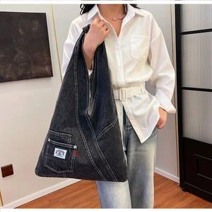 Detailed macro view of dark grey washed denim tote bag with white contrast stitching