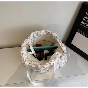 Internal view of a floral canvas tote bag showing large capacity and zipper pocket