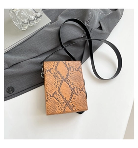 Flat lay of vintage burnt orange snake pattern crossbody bag with silver hardware