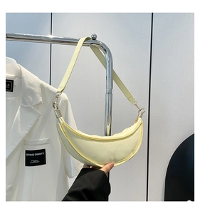 Detail of light yellow crescent dumpling bag showing high-density fabric and zipper closure