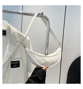 Detail of white crescent shoulder bag with golden hardware and smooth zip closure