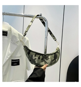 Detail of camouflage crescent bag featuring smooth metal zipper and tactical street style