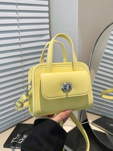 Minimalist light yellow rectangular handbag with adjustable strap in bright interior