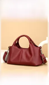 Detailed view of dark red leather tote featuring lychee texture and woven handle