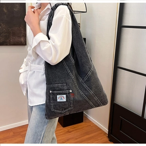 Close-up of retro washed denim tote bag showing contrasting stitching and brand label