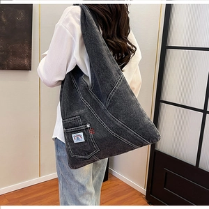 Detailed view of dark grey washed denim shoulder bag with functional front pocket