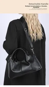 Detail of black pebbled leather tote bag with woven handle and detachable shoulder strap