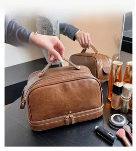Macro detail of brown leather toiletry bag featuring dual layers and metal zippers