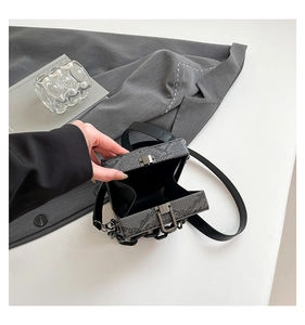 Macro view of the interior space of the python pattern box bag with metal lock closure
