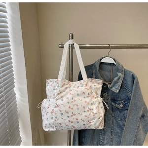 Detailed side view of floral tote bag showing functional drawstring pocket and canvas texture
