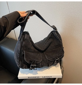 Detail of black denim motorcycle bag showing cargo pockets and metallic buckles
