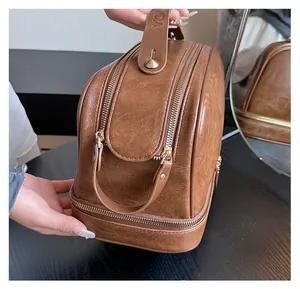 Detail of vintage brown leather cosmetic bag with double zipper and organized sections