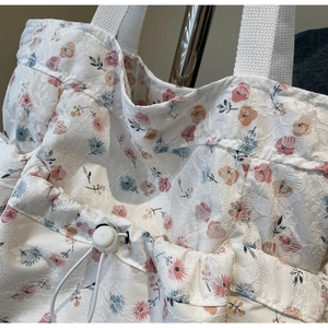 Detailed macro view of white floral lace fabric with a drawstring and toggle closure
