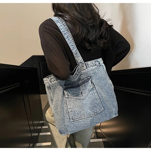 Macro shot of vintage denim tote bag showing the side pocket detail and shoulder strap wear