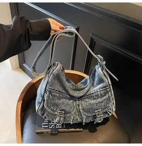 Detailed close-up of retro washed denim crossbody bag featuring dual pockets and metal buckles