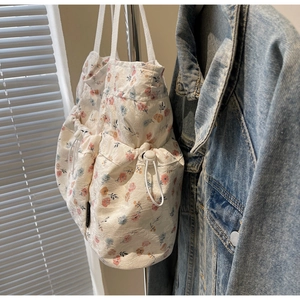 Close-up of white floral tote bag with jacquard texture and side drawstring detail