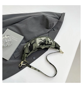 Detail view of camouflage dumpling chest bag with gold-tone hardware on grey blazer