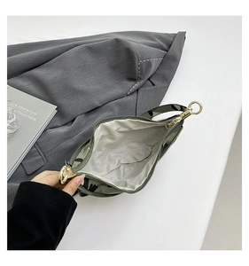 Detailed top view of camouflage crossbody bag interior with gold zippers and grey lining