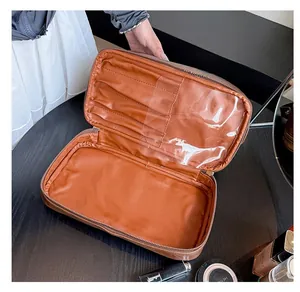 Detail showing the brown leather makeup bag interior with brush slots and clear plastic cover