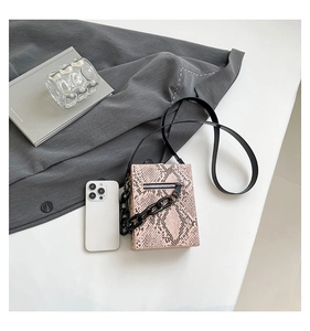 Mini pink snakeskin pattern crossbody bag with black chunky chain and phone for size reference