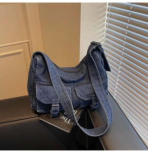 Detail view of the vintage denim motorcycle bag with metal buckles and washed fabric