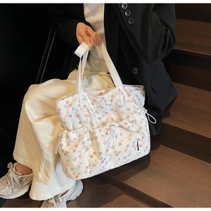 Detail of floral tote bag showing drawstring pockets and vintage flower patterns