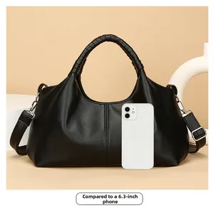 Detail of black pebbled leather tote bag size comparison with a 6.3-inch mobile phone