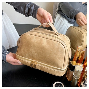Detail of a large capacity cream leather makeup bag with double layers and sturdy handle