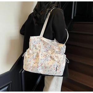 Floral print tote bag featuring decorative drawstring pockets and high-capacity canvas design