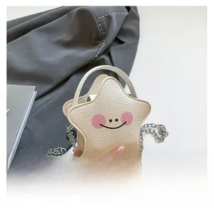 Detail view of mini star-shaped crossbody bag with smiling face and silver chain strap