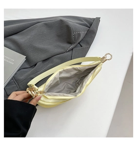Detailed interior of minimalist cream dumpling bag showing spacious compartment and gray lining