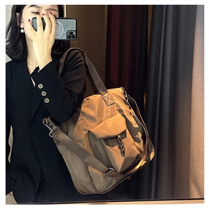 Detail of coffee brown waterproof nylon tote bag with metal buckle and shoulder strap