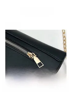 Détails de la fermeture éclair dorée et de la chaîne sur un sac à main en cuir noir
