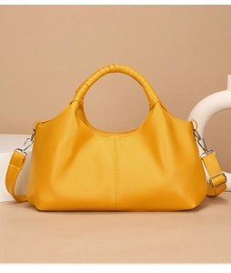 Detail of yellow lychee grain leather bag showing woven handle and silver hardware