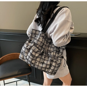 Detail of checkered tote bag showing multiple side pockets and elastic drawstring closure