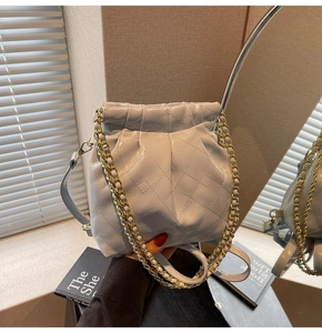 Detailed view of light blue quilted leather bag with elegant gold chain strap