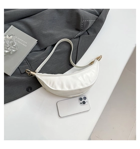 Detailed top view of white crescent bag with glossy finish and phone for size reference