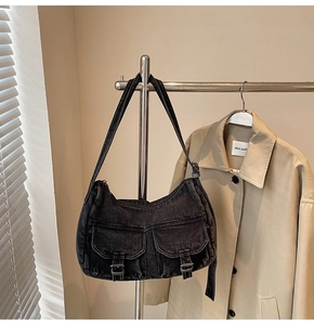 Detailed view of gray washed denim hobo bag with vintage metal buckles and cargo pockets