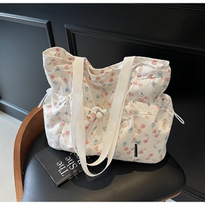 Detailed macro view of the floral tote bag with textured jacquard fabric and side drawstrings