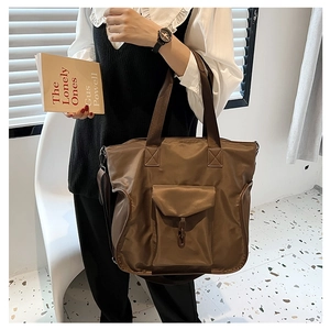 Detail of waterproof nylon tote bag showing reinforced handles and ring buckle pocket