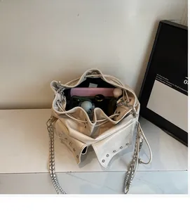 Macro top view of off-white rivet bucket bag showing spacious interior with daily items