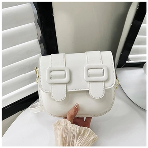 Détail du sac besace en cuir PU blanc avec boucles à lanières verticales et rabat