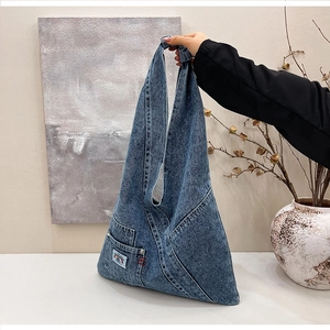Detail of washed denim hobo bag showing functional pocket and rainbow patch detail