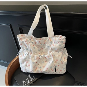 Detail of floral canvas tote bag with drawstring front pocket and colorful flower pattern