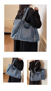 Detail of blue denim tote bag showing vintage washed texture and large front pocket