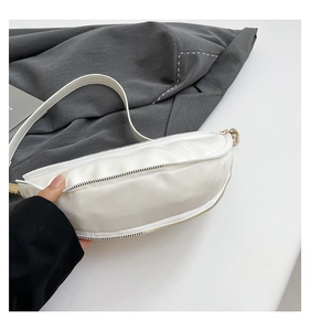 Detailed macro view of white PU leather dumpling bag with premium gold metal hardware